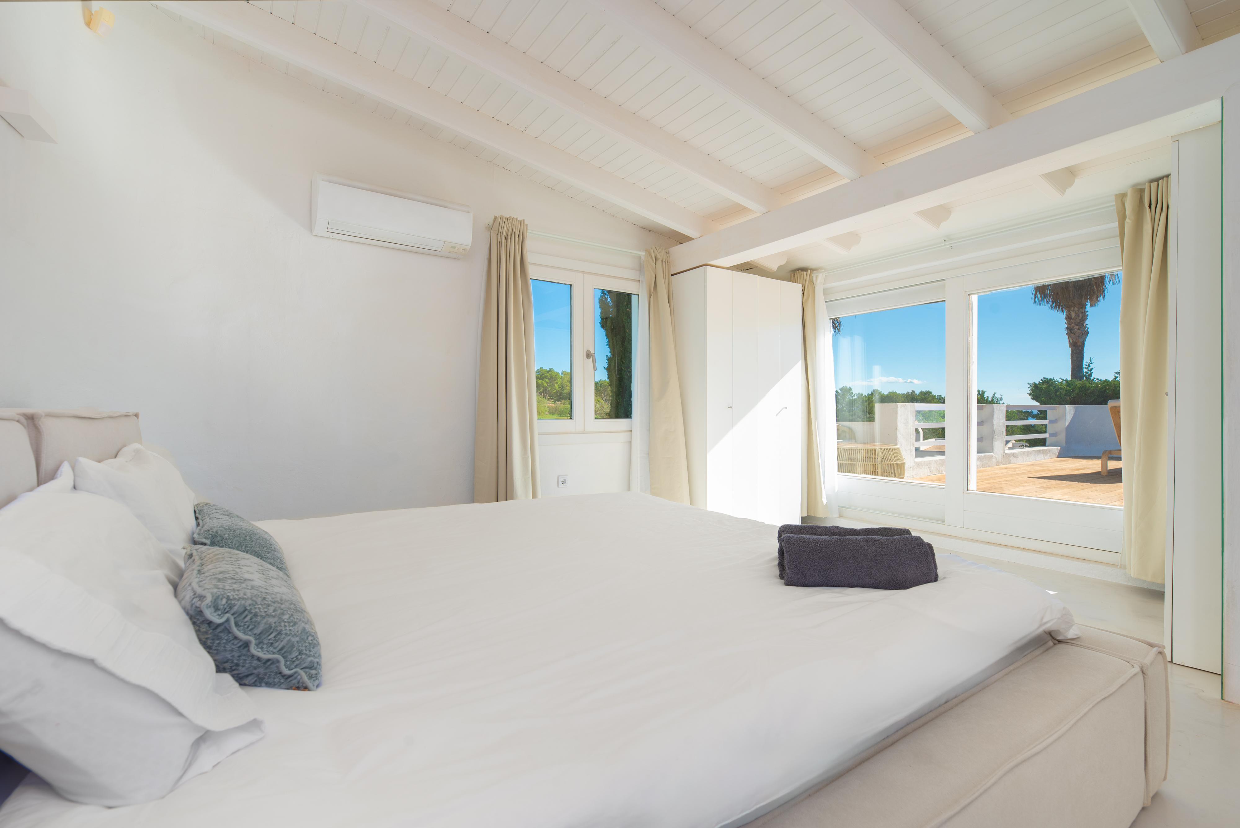 Villa Jondal master bedroom — white linens, exposed beams, natural Mediterranean light